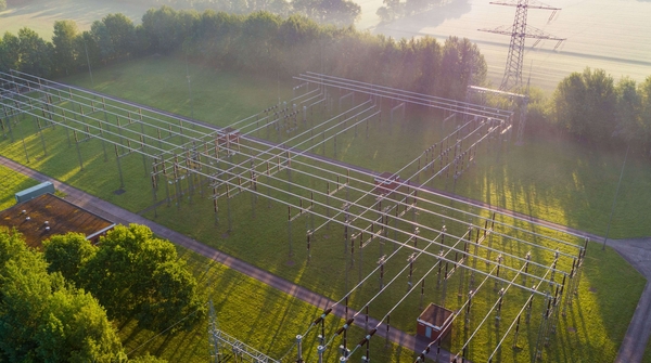 Luftaufnahme eines Umspannwerks in der Natur vor einem Sonnenaufgang